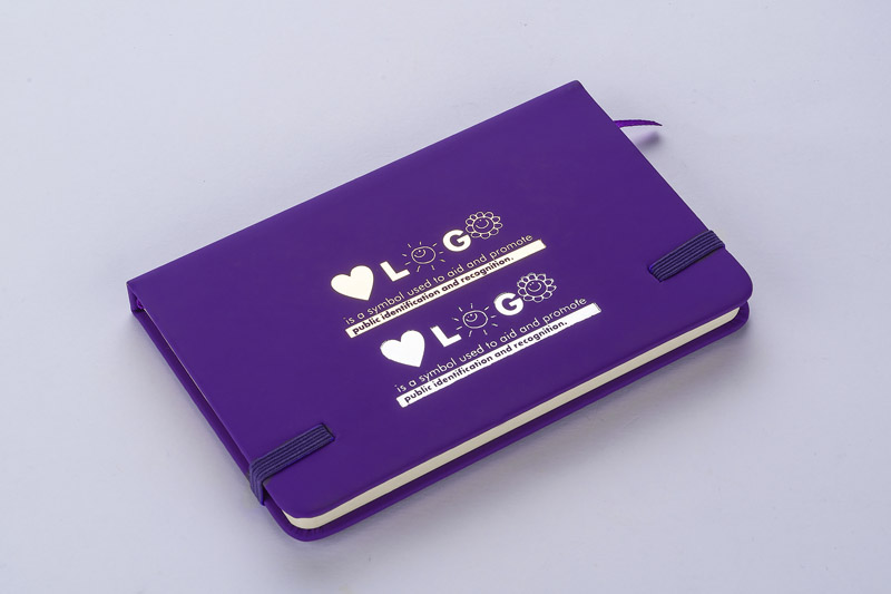 Notes VITAL A6
Gustowny notes A6 z kolorową gumką wykonany z ekoskóry PU. Notes zawiera 80 kartek ecru w linie koloru pomarańczowego. Logo nadrukujemy na okładce.