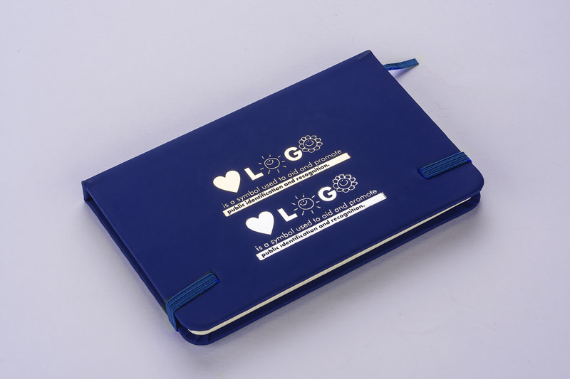 Notes VITAL A6 Gustowny notes A6 z kolorową gumką wykonany z ekoskóry PU. Notes zawiera 80 kartek ecru w linie koloru pomarańczowego. Logo nadrukujemy na okładce.